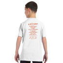A boy wears the Latitude Kids 2024 Line Up White T-Shirt from the Latitude Festival Store, featuring Duran Duran and Kasabian on the back in orange text—perfect casual wear for kids. Event: 25–28 July 2024.